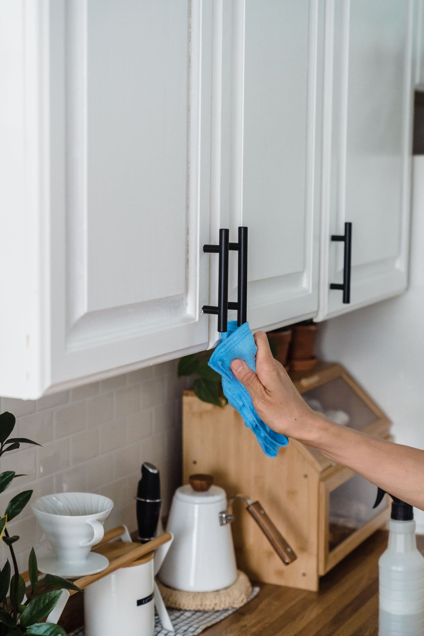 Adjusting a kitchen cupboard door hinge with a screwdriver