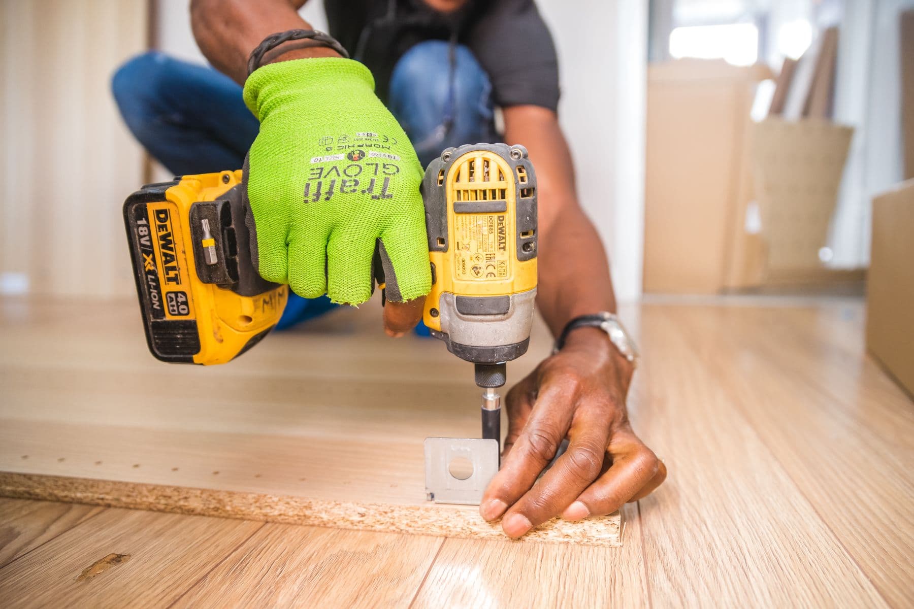 Assembling flat pack furniture with hand tools on a floor