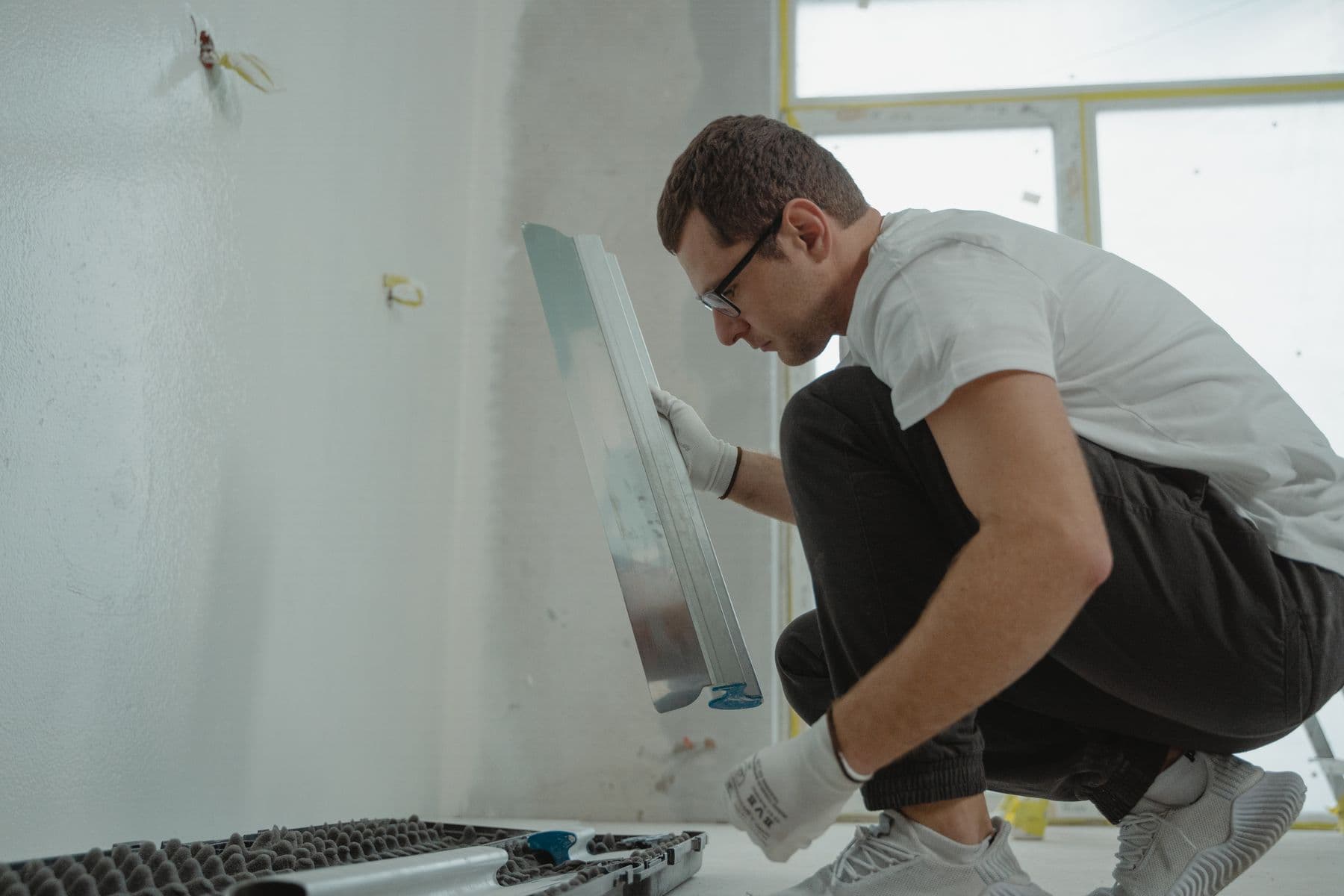 Painting a wall edge with a brush and roller